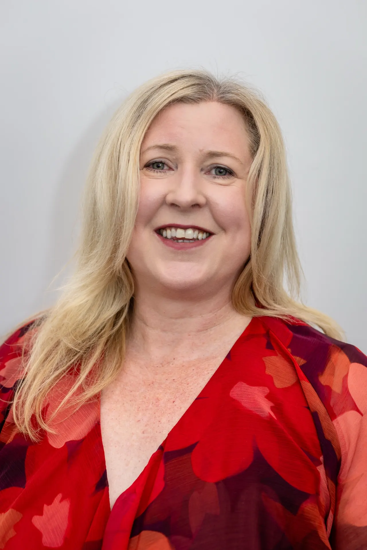 Dr Kylie Dodsworth smiling, wearing a red floral top