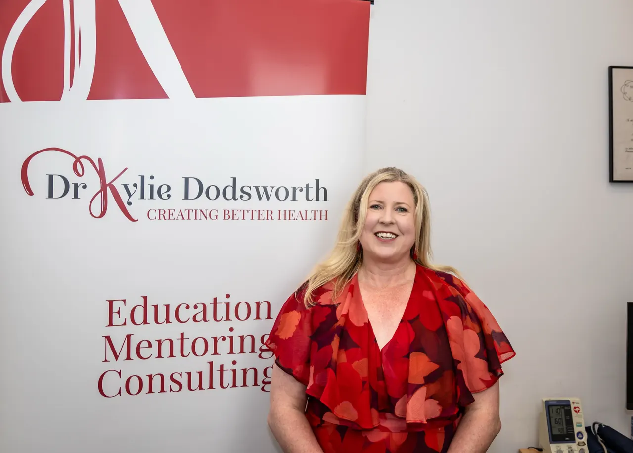 Dr Kylie Dodsworth beside the Centre for Health and Wellbeing banner